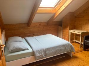 1 dormitorio con 1 cama en una habitación con ventana en Houten chalet/bungalow in het bos, sauna, jacuzzi, en Meijel