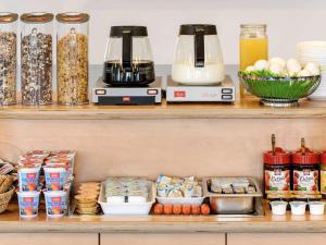 un estante con alimentos y electrodomésticos en ibis budget Ulm City, en Ulm