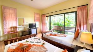Un dormitorio con dos camas y una gran ventana. en Sawaddee Aonang Resort, en Ao Nang Beach