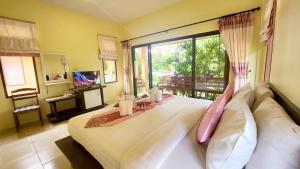 a bedroom with a large bed with a large window at Sawaddee Aonang Resort in Ao Nang Beach