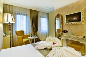 Ein Zimmer mit einem Wohnzimmer, einem Kamin und einer Schwanenstatue in der Unterkunft Edibe Sultan Hotel in Istanbul