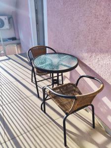two tables and chairs sitting on a porch at Apartment Loft in Sinj