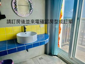 uma casa de banho com um lavatório e uma janela em Kenting Bayview Hotel em Nanwan