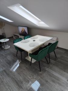 a dining room with a table and green chairs at Apartment Loft in Sinj