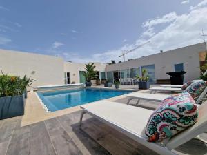 una casa con piscina y sillas en un patio en Azalea Dreams by Santa Marija Estate, en Mellieħa