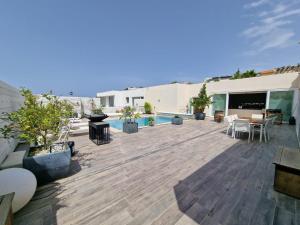 um pátio com uma piscina, mesas e cadeiras em Azalea Dreams by Santa Marija Estate em Mellieħa