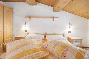 two beds in a room with wooden ceilings at Appartamenti Elisabetta n1 in Livigno