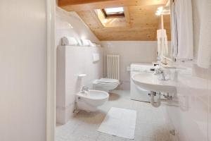 a white bathroom with a toilet and a sink at Appartamenti Elisabetta n1 in Livigno