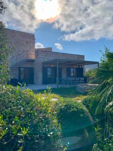 een stenen huis met een veranda in een tuin bij Villa Camarò in Favignana