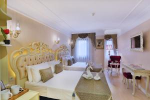 Edibe Sultan Hotel في إسطنبول: غرفة نوم مع سرير أبيض كبير ومكتب