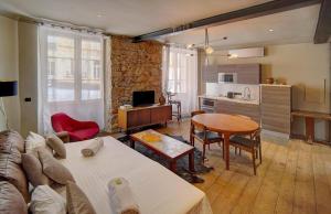 a living room with a couch and a table and a kitchen at Red & Bleue YourHostHelper in Cannes