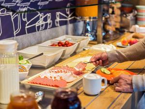 a person is preparing food on a table at ibis budget Muenchen Putzbrunn in Putzbrunn