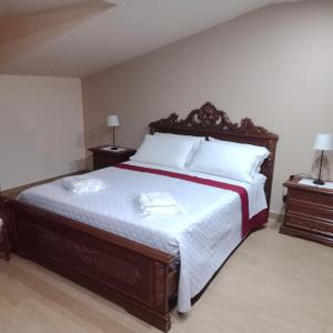 una camera con un grande letto e due comodini di Alkantara Holiday a Francavilla di Sicilia