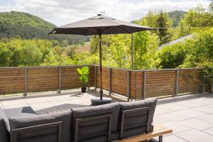 a patio with an umbrella and a table and chairs at Die entspannendste Wohnung am Edersee - SPA Sauna in Giflitz