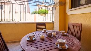 Welcomely - La Porta Sul Mare في غولفو أرانتْشي: طاولة خشبية عليها أكواب وأبريق الشاي