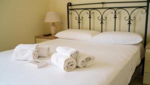 Welcomely - La Porta Sul Mare في غولفو أرانتْشي: غرفة نوم بسريرين مع مناشف بيضاء