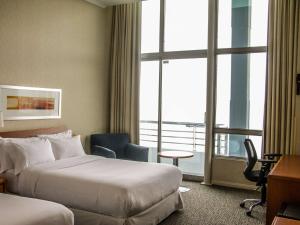 um quarto de hotel com duas camas e uma janela em Novotel Puerto Montt em Puerto Montt