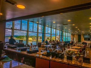 a restaurant with a bar with a view of the water at Novotel Puerto Montt in Puerto Montt