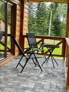 a patio with two chairs and a table on a porch at Borówkowy Jar in Ropienka