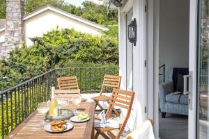 a wooden table with plates of food on a balcony at The Retreat, Brixham in Brixham
