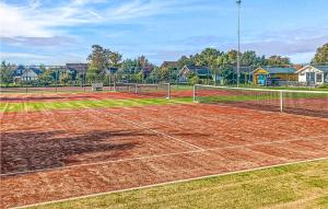 a tennis court with a net on a dirt court at Stunning stacaravan In Tzummarum With Kitchen in Tzummarum
