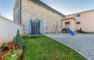 a yard with two swings and a playground at 3 Bedroom Cozy Home In Svetvincenat in Svetvinčenat