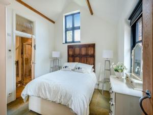 a bedroom with a bed and a sink and windows at The Victorian Stables in Kimpton