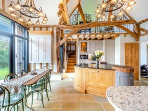 a kitchen with wooden ceilings and tables and chairs at The Victorian Stables in Kimpton