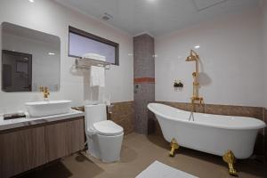 a bathroom with a tub and a toilet and a sink at DONG PHUONG HOTEL in Bao Loc +47 photos