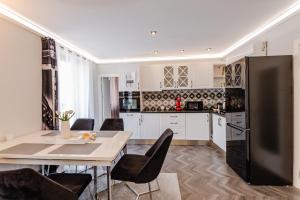 uma cozinha com uma mesa e um frigorífico preto em Апартаменти Стефани em Plovdiv