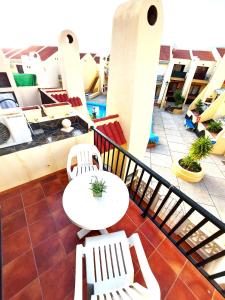 - un balcon avec deux chaises blanches et une table dans l'établissement Mareverde, wifi free, à Adeje