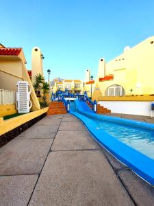 a swimming pool at a resort with a blue slide at Mareverde, wifi free in Adeje