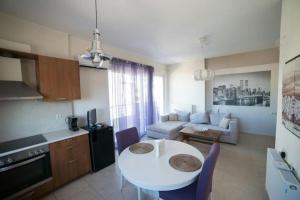 cocina y sala de estar con mesa blanca y sillas en Significant view, close to center Heraklion with parking, en Heraclión