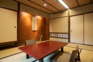 a conference room with a wooden table and chairs at Ryokan Sumiya Kihoan in Kameoka +208 photos