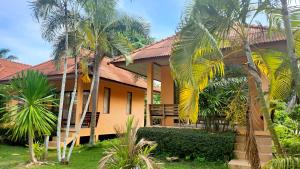 a house with palm trees in front of it at Sawaddee Aonang Resort in Ao Nang Beach