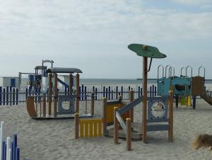 um parque infantil na areia na praia em Maison La Côte em Boulogne-sur-Mer