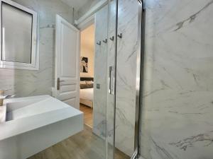 a white bathroom with a shower and a sink at Barcelonaforrent The Gaudí Suites in Barcelona