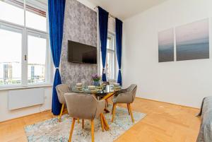 - un salon avec une table, des chaises et une télévision dans l'établissement BluebellHome-Castle District, à Budapest