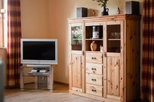 a large wooden entertainment center with a television in a living room at Sonnenschein, Ferienwohnung in Jesteburg