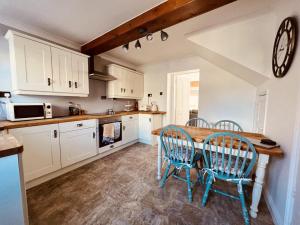 uma cozinha com uma mesa de madeira e cadeiras em Cosy cottage four miles from Lincoln city centre em Lincoln
