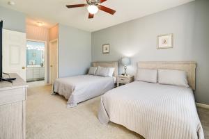 two beds in a bedroom with a ceiling fan at Myrtle Beach Golf Retreat with Pool Access! in Myrtle Beach