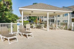 einen Pavillon mit Stühlen und Tischen auf einer Terrasse in der Unterkunft Myrtle Beach Condo Golf Courses and Pool Access! in Myrtle Beach