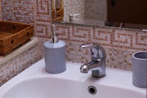 a bathroom sink with a soap dispenser on it at Cozy Studio with Rooftop Terrace & Cityscape Views in Le Bardo