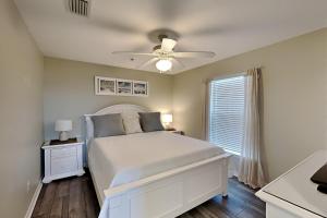 a bedroom with a white bed and a ceiling fan at Gulf Island #134 - White Sands Condo in Navarre +15 photos