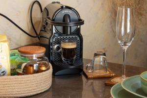 a coffee maker sitting on a table next to a wine glass at Cozy Studio with Rooftop Terrace & Cityscape Views in Le Bardo