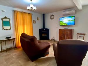 sala de estar con sofá y TV en Casilla Soleá, en Carcabuey
