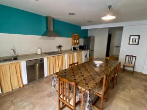cocina con mesa y sillas y cocina con paredes azules en Casilla Soleá, en Carcabuey