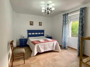 1 dormitorio con 1 cama, 1 silla y 1 ventana en Casilla Soleá, en Carcabuey