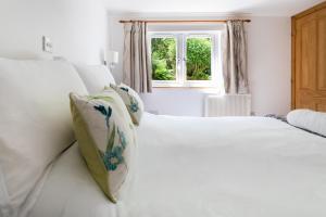 2 camas blancas en una habitación con ventana en Merrivale Barn en Constantine