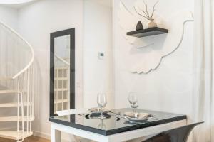 a dining room with a glass table with two wine glasses at Inviting duplex in front of Picasso Museum by REMS in Málaga +20 photos